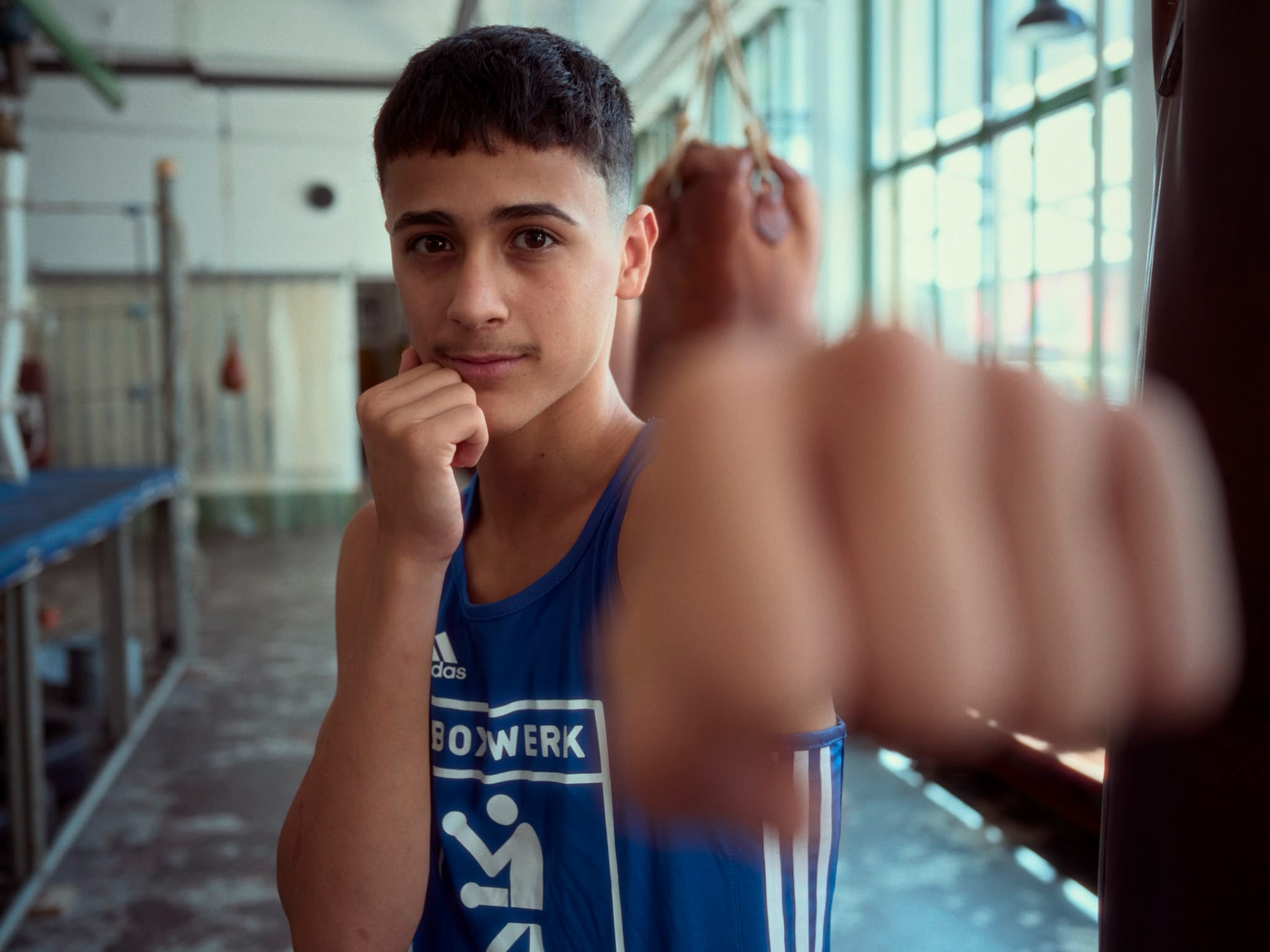 Young Boxwerk boxer resting against a heavy bag at Boxwerk Munich